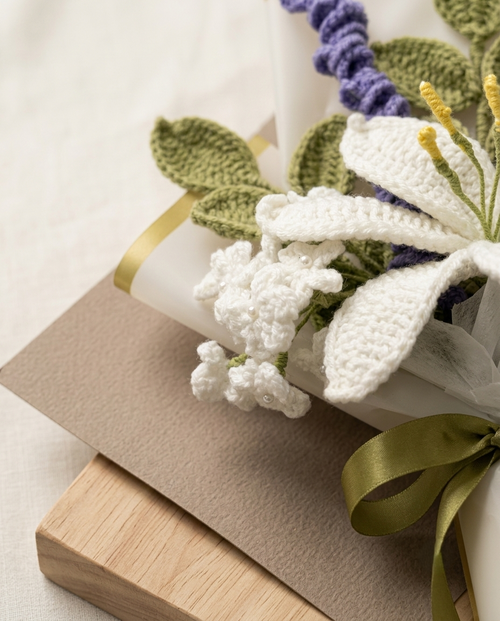 Close view of the crochet lily petals, pearl-tipped white blooms and gold-edged paper wrap