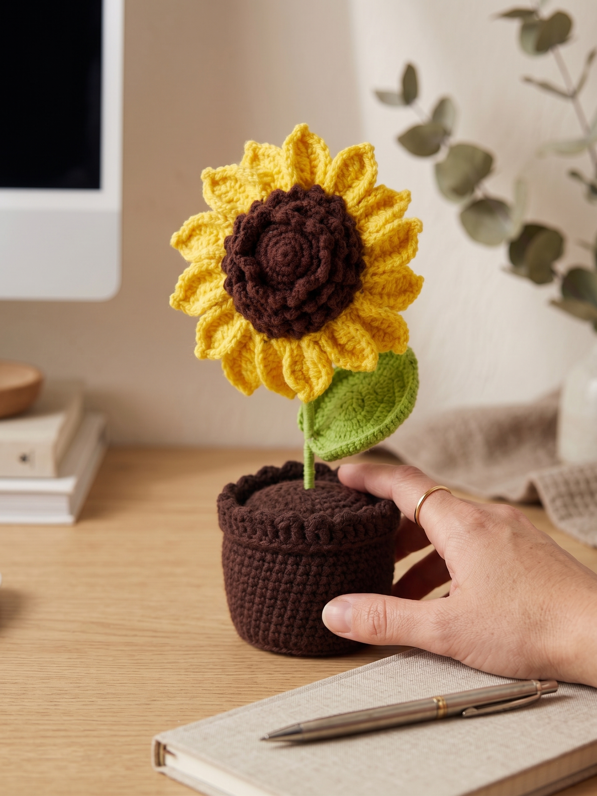 The sunflower pot styled beside desk objects
