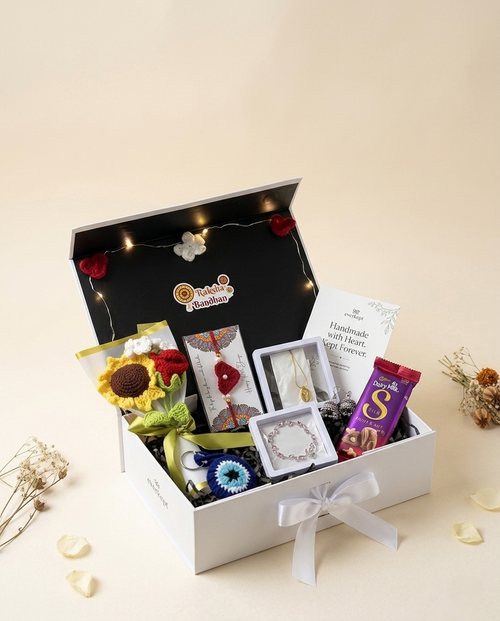 Open Everkept Rakhi hamper box with a Raksha Bandhan badge, fairy lights, crochet sunflower bouquet, rakhis, jewellery boxes and chocolate