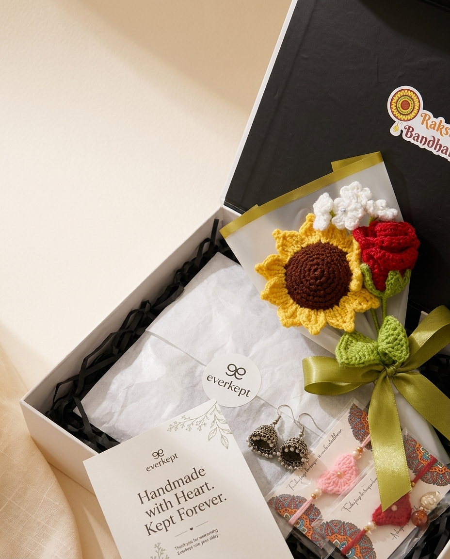 Close view inside the hamper: tissue-wrapped crochet bouquet, jhumka earrings and rakhis under the lit Raksha Bandhan lid
